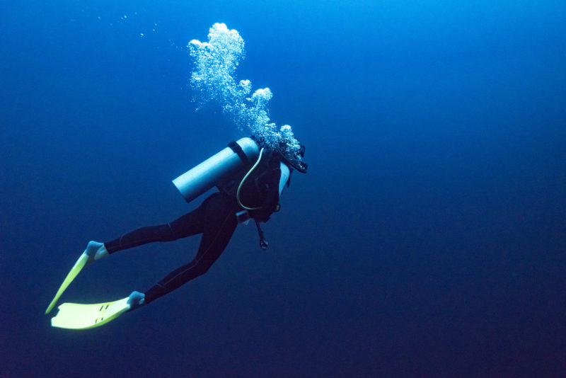 Scuba diver underwater with air bubbles
